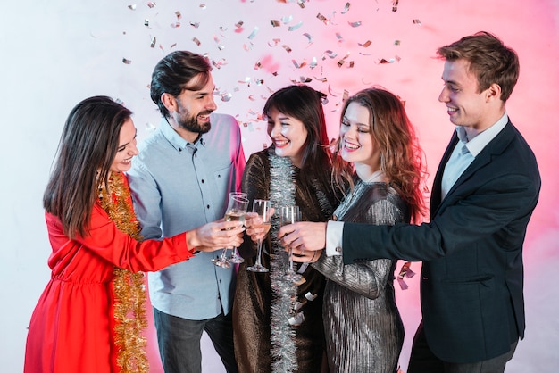 Amici che celebrano il Natale e bicchieri di champagne tintinnanti