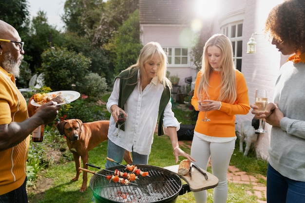 Amici che fanno barbecue in ambiente rurale