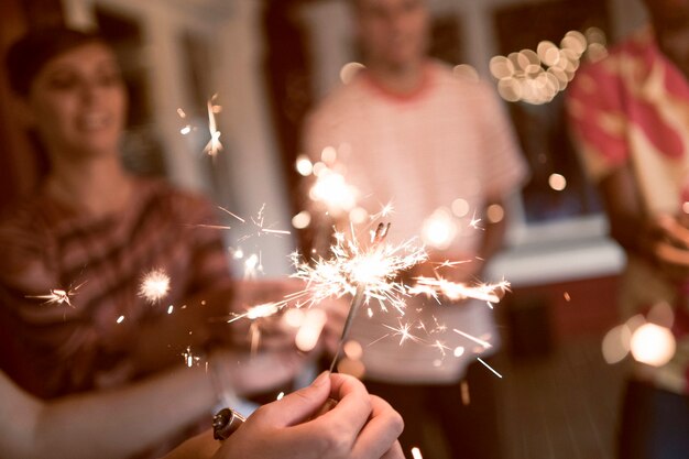 Amici che fanno festa con fuochi d'artificio ad alto angolo