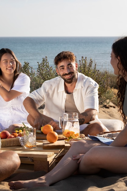 Amici che fanno una festa di sangria sulla spiaggia