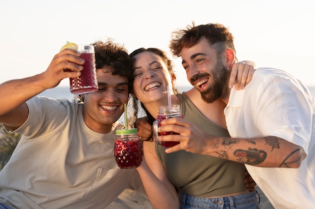 Amici che fanno una festa di sangria sulla spiaggia