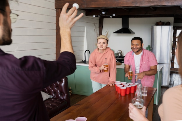 Amici che giocano a beer pong insieme a una festa