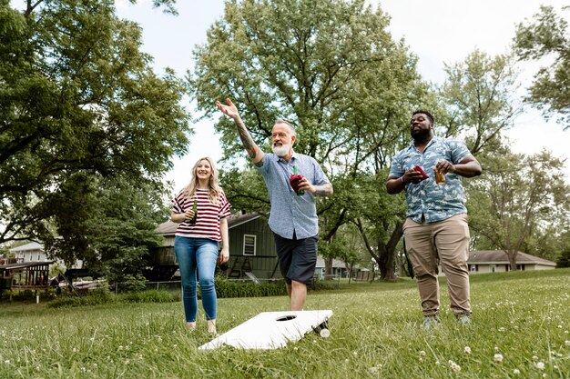 Amici che giocano a cornhole a una festa estiva nel parco