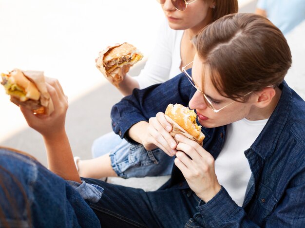 Amici che godono di alcuni hamburger all'aperto