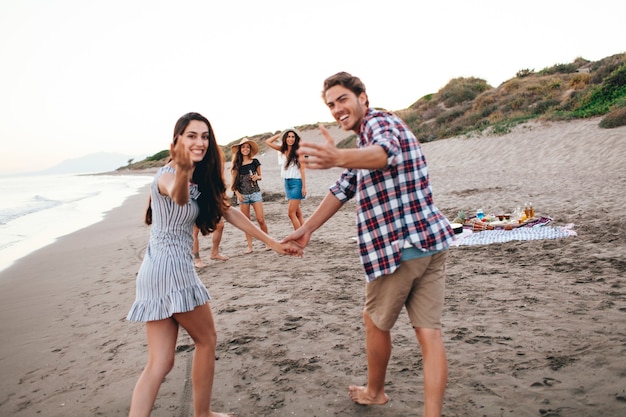 Amici che hanno un buon tempo in spiaggia