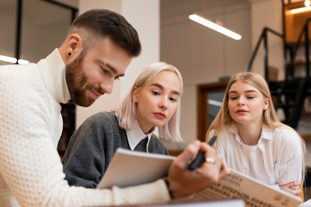 Amici che leggono da un taccuino durante la sessione di studio