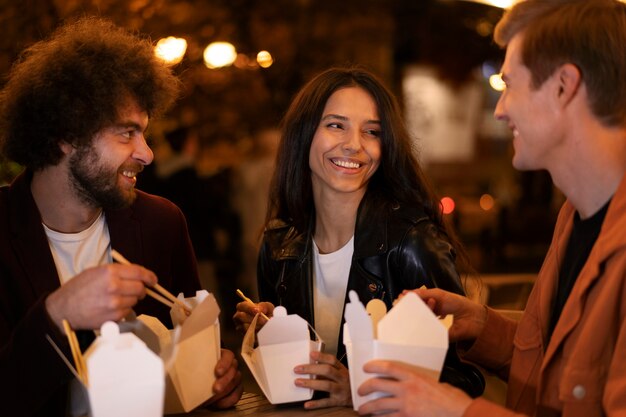 Amici che mangiano cibo cinese insieme durante una serata fuori