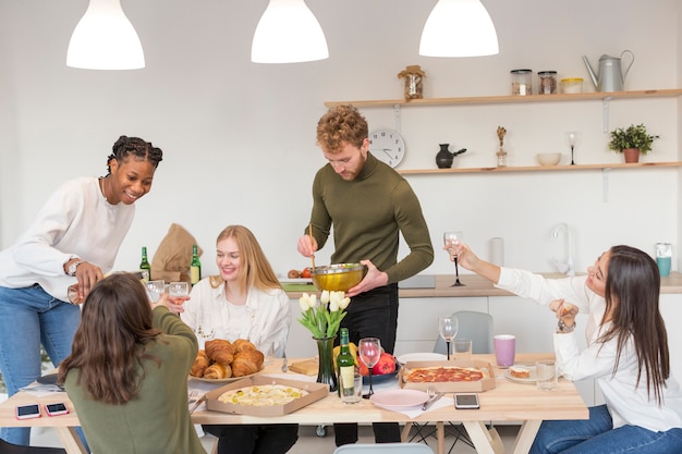 Amici che mangiano insieme a casa