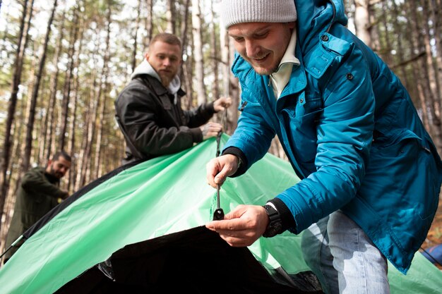 Amici che montano la loro tenda da campeggio invernale