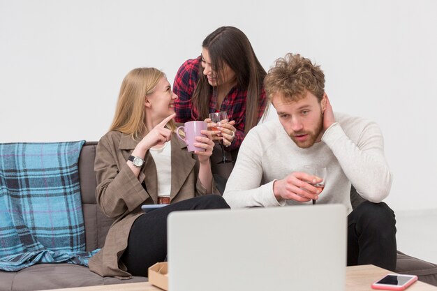 Amici che osservano sul computer portatile durante il pranzo