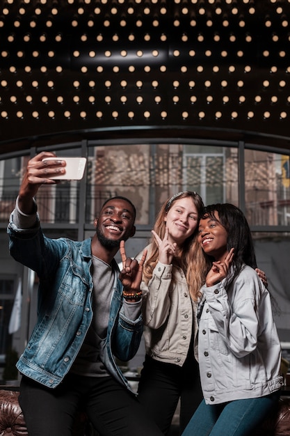 Amici che posano per il tiro medio di selfie