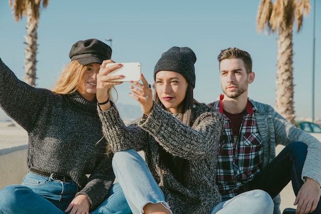 Amici che prendono selfie davanti a palme