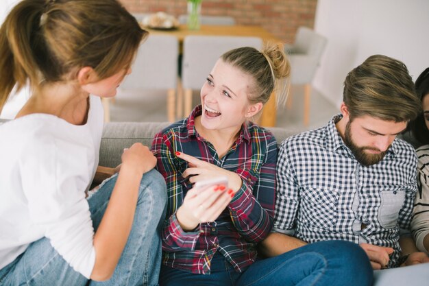 Amici che ridono passare il tempo con i gadget