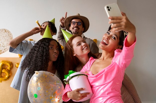Amici che si fanno selfie durante una festa di compleanno a sorpresa