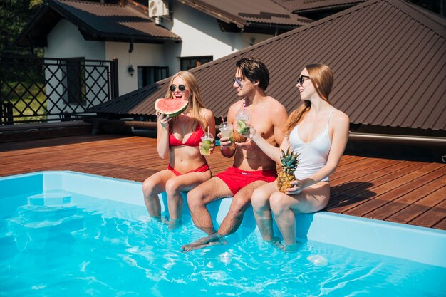 Amici che si godono le vacanze in piscina