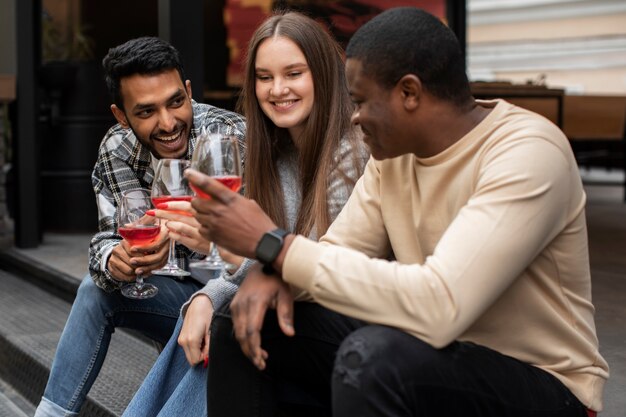 Amici che sorridono mentre tengono in mano un drink