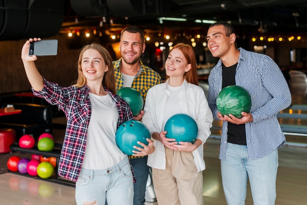 Amici che tengono le palle da bowling colorate