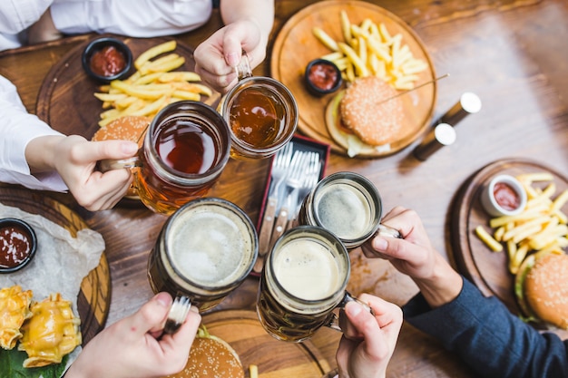 Amici che tostano con la birra nel ristorante