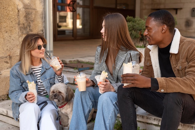 Amici che vanno in giro gustando una tazza di caffè