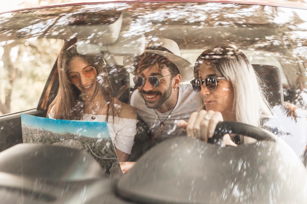 Amici che viaggiano in auto guardando la mappa