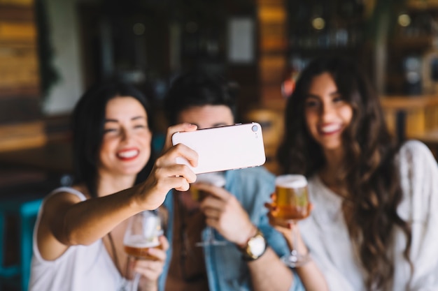 Amici con birra che prendono selfie