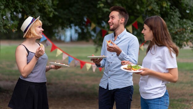 Amici del colpo medio che tengono piatti del cibo