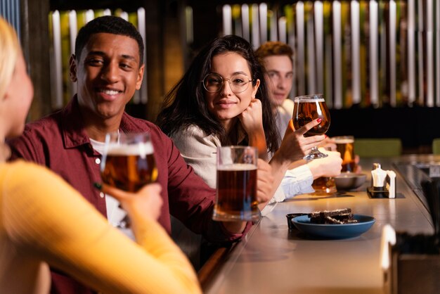 Amici del primo piano che si siedono con la birra