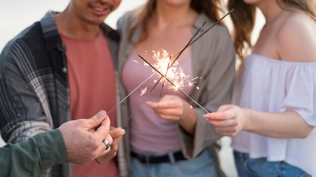 Amici del primo piano che tengono i fuochi d'artificio