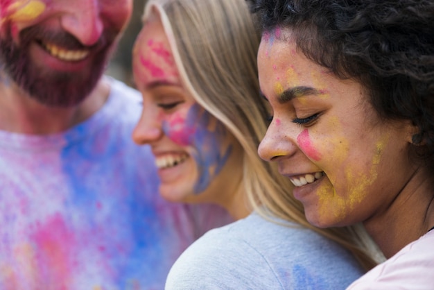 Amici del primo piano coperti in pittura a holi