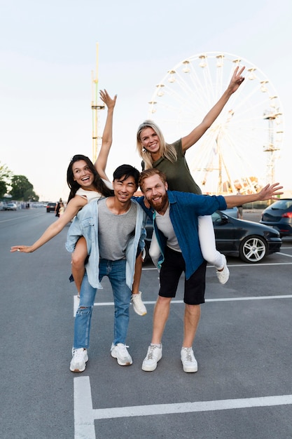 Amici della foto a figura intera che posano nel parcheggio