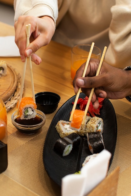 Amici di alto angolo che mangiano sushi a casa