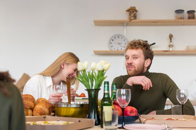 Amici di angolo basso che mangiano insieme