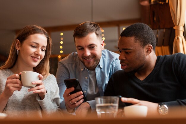 Amici di angolo basso che osservano sul telefono