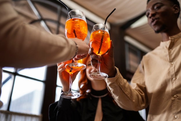 Amici di angolo basso che tengono cocktail