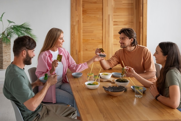 Amici di medio livello che mangiano snack alle alghe