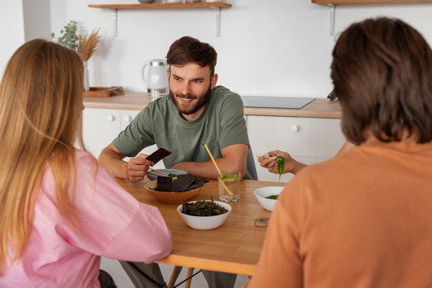 Amici di medio livello che mangiano snack alle alghe