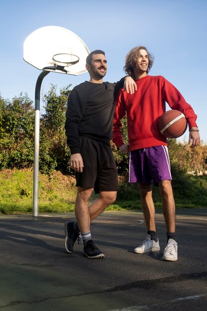Amici di mezza età che si divertono insieme giocando a basket
