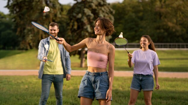 Amici di smiley di vista frontale che giocano a badminton