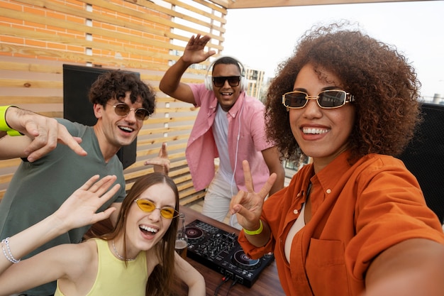 Amici di smiley di vista laterale che prendono selfie