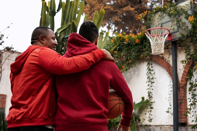 Amici di tiro medio che giocano a basket all'aperto