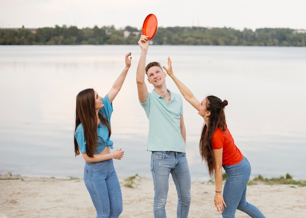 Amici di tiro medio che giocano con il frisbee