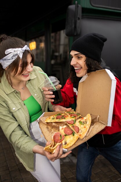 Amici di tiro medio che mangiano fast food in modo divertente