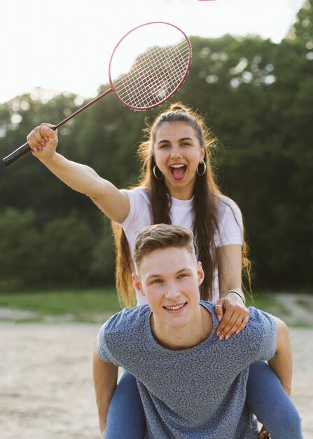 Amici di tiro medio che si divertono con la racchetta da badminton