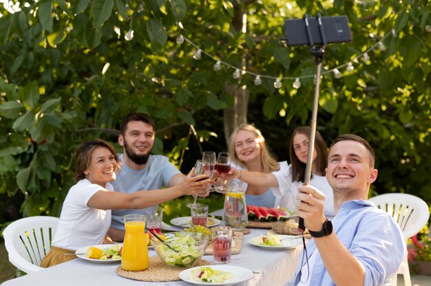 Amici di tiro medio che si fanno selfie all'aperto