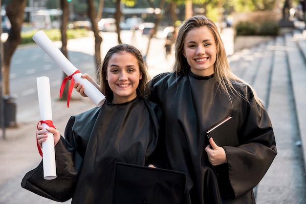 Amici di vista frontale alla loro cerimonia di laurea