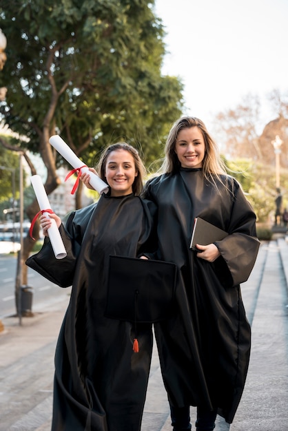 Amici di vista frontale che posano alla loro laurea