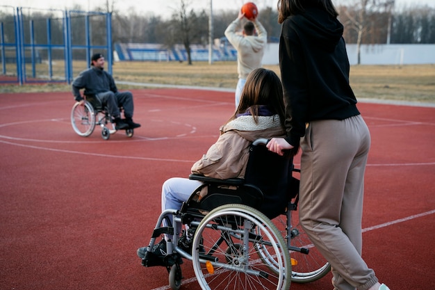 Amici di vista laterale che giocano a basket insieme