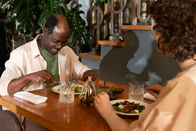 Amici di vista laterale che mangiano al ristorante