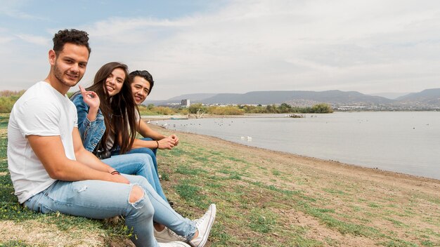 Amici di vista laterale che si siedono in riva al mare