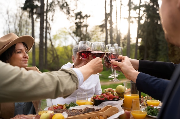 Amici di vista laterale che tengono bicchieri di vino